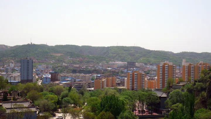 View of a town nestled among hills, seen from a mountainside in Xi County