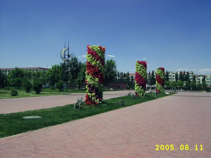 Decorative flower-covered columns in a paved public square, Jiuyuan District