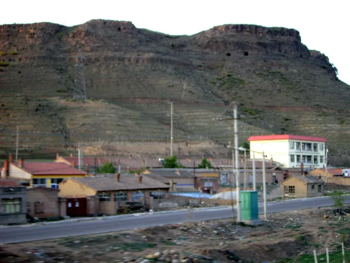 A rocky mountain overlooking a small town in Zhuozi County