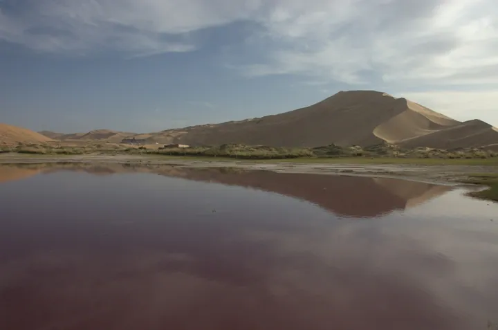 Sand dunes reflected in a lake in the Badain Jaran Desert, Alxa Right Banner