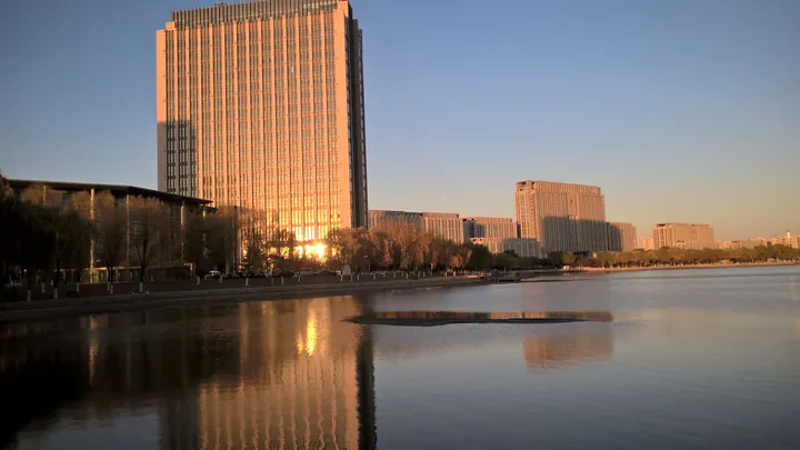 High-rise building reflected in a lake at sunset in Tieling County