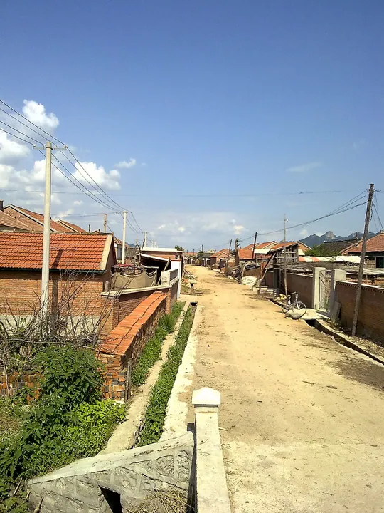 A rural village lane lined with brick houses in Kaiyuan, Liaoning