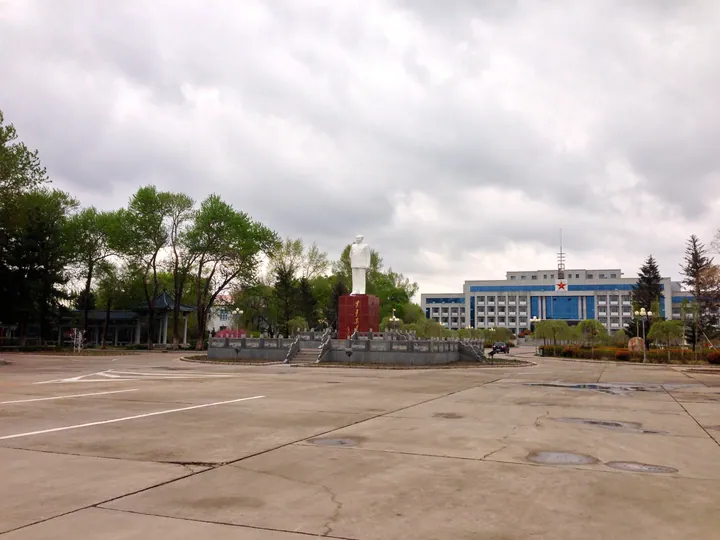 Overcast civic plaza with a statue and government building in Taobei District