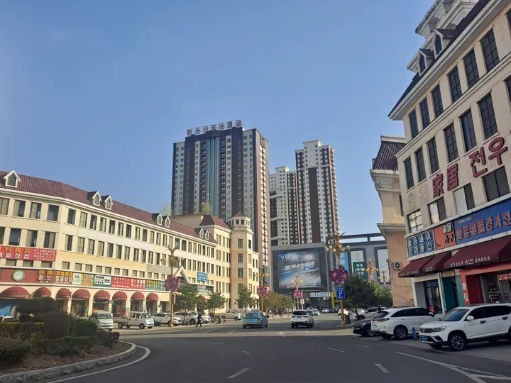 A wide city street lined with tall buildings in Wangqing
