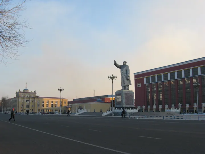 A civic square with a statue and surrounding buildings in Fularji District
