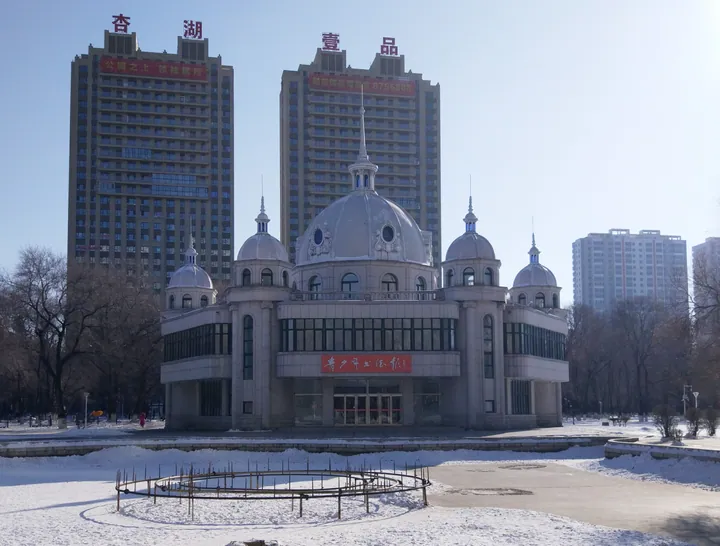 A domed hexagonal pavilion building beside a park lake