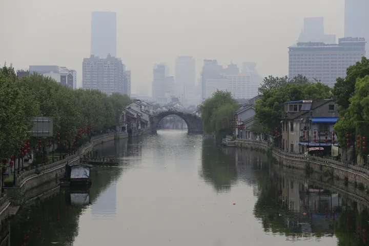 Stone arch bridge over a canal lined with traditional houses in Liangxi District, Wuxi