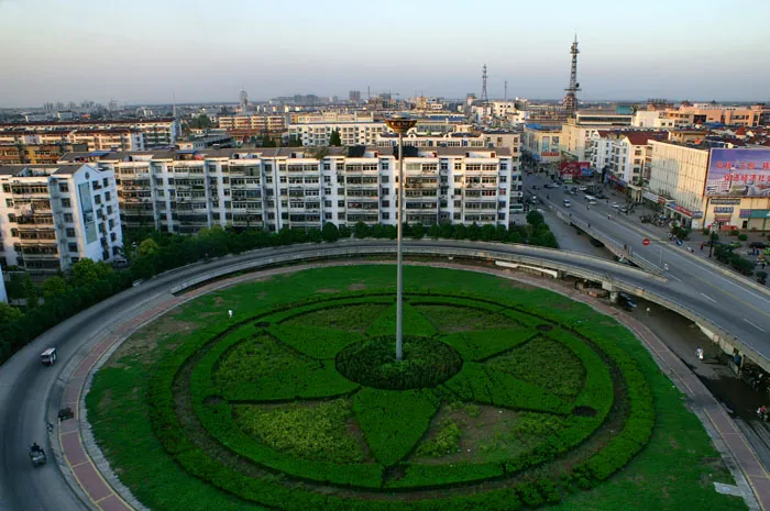 Aerial view of a landscaped roundabout and overpass in Pizhou