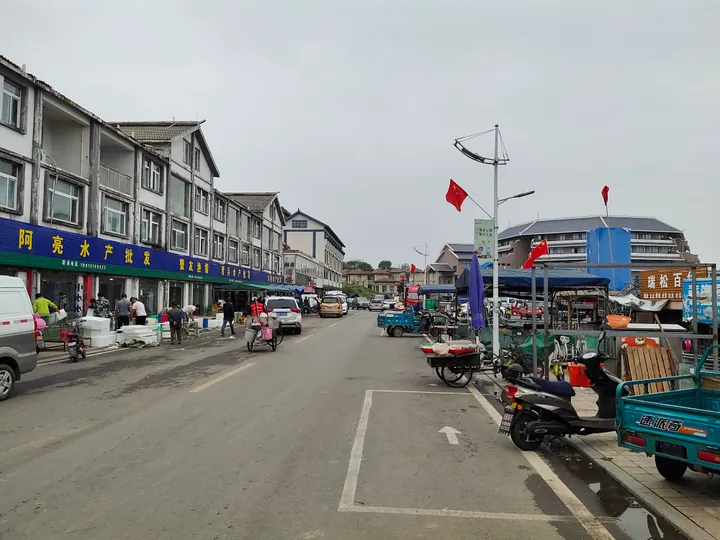 A lively street with shops, vendors and mopeds in Laozishan Town, Hongze District