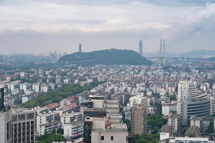 A birds-eye view of Zhenhai's urban district with a hill and pagoda in the middle distance
