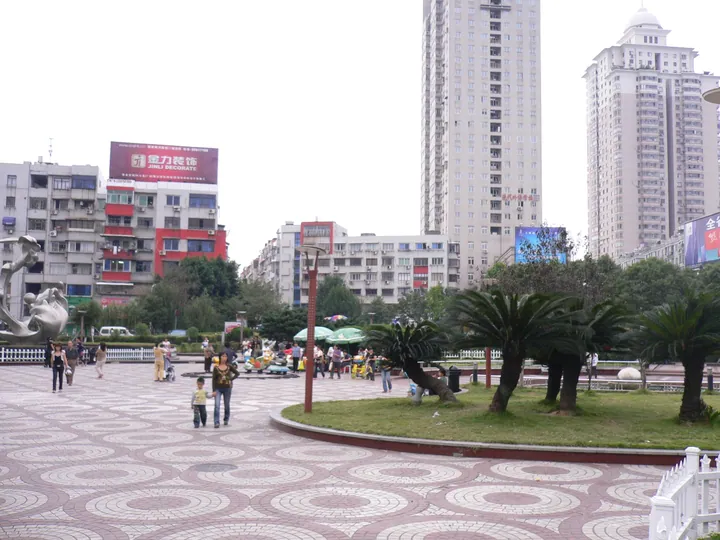 Plaza with a fountain, trees and apartment towers at Yuhai Square in Rui'an