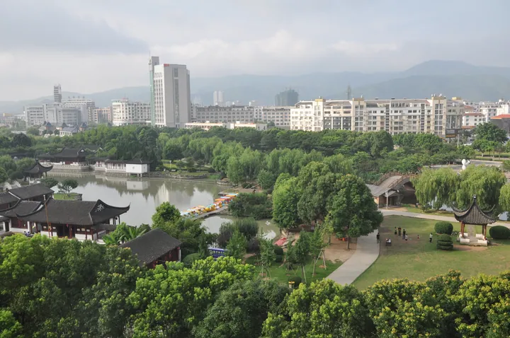 Elevated view of Yuhuan Park with lake, pavilions and the city skyline