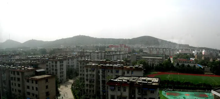 Panoramic skyline of apartment blocks with hills in the background, Tianjia'an District