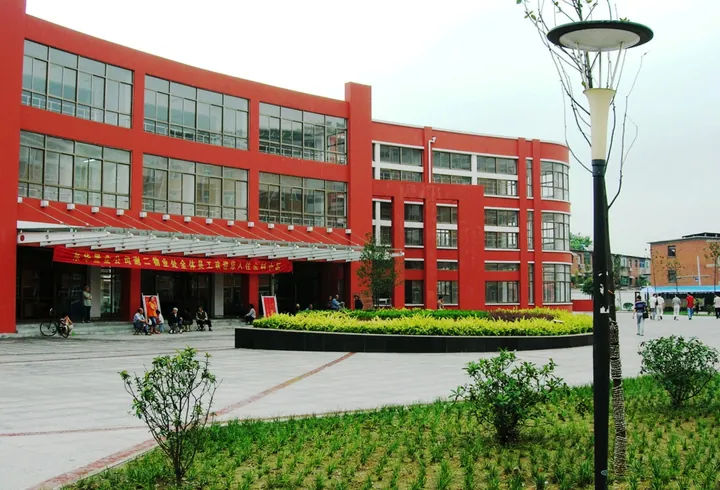 Red-facade residential building with a landscaped plaza, Xiejiaji District