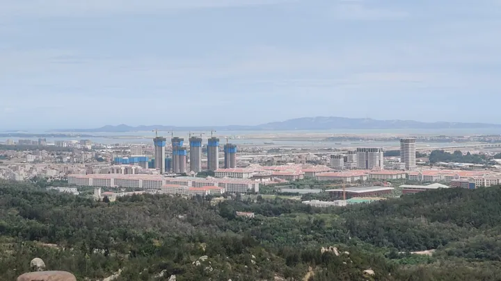 Aerial view of apartment towers and low-rise buildings in Xiang'an District with the coast in the distance