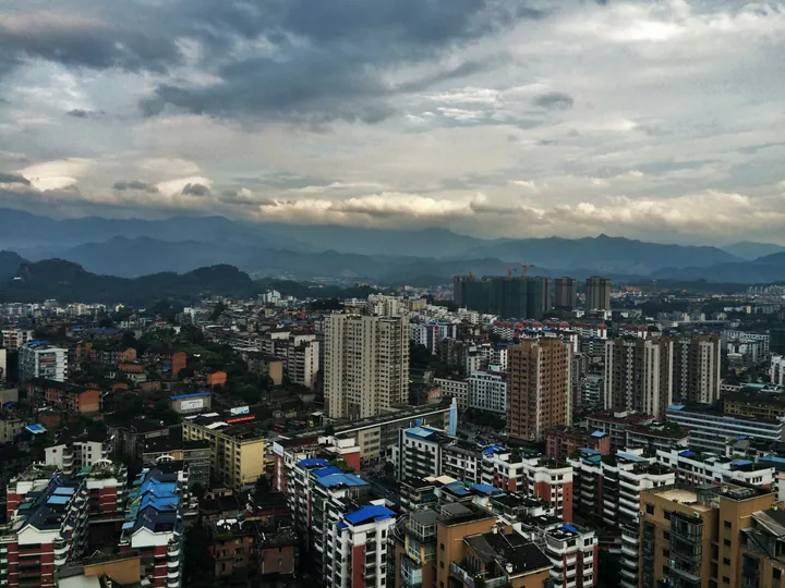Cityscape of Yong'an with multi-storey buildings and hills in the background