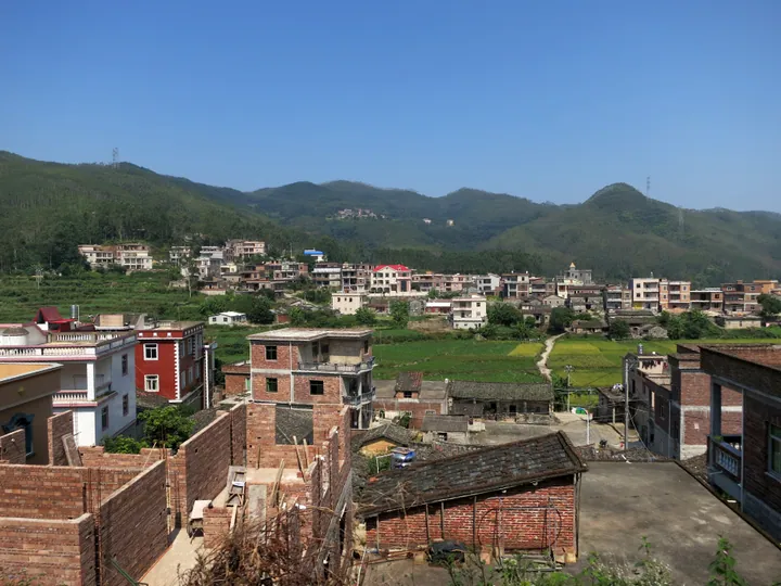 Village houses set among hills and farmland in Quangang District