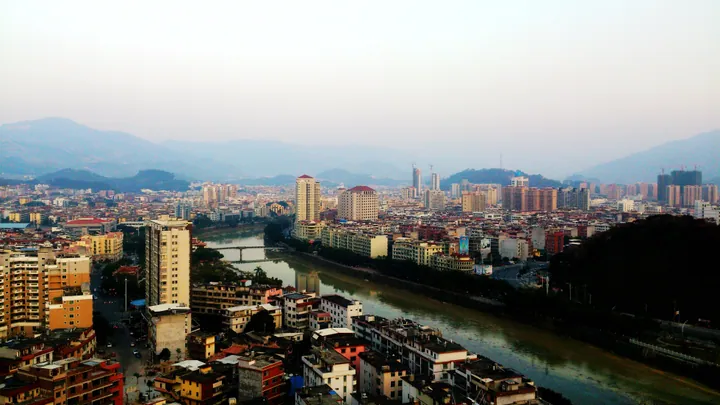 Townscape of Yongchun County seat along the river, with mountains behind