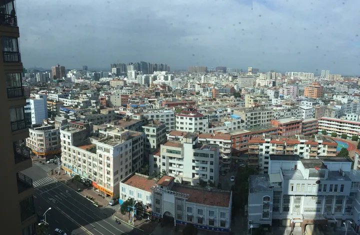 Elevated view of dense downtown rooftops and high-rises in Shishi