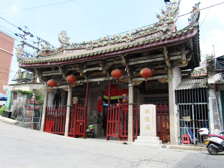 An ornate temple gate with red lanterns and a dragon-decorated roof