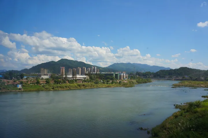Riverside view of Guangze County's built-up area along the Beixi Brook, with mountains behind
