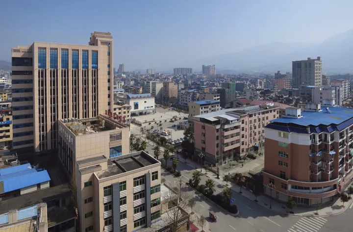 Elevated view of Songxi County town with a hotel building and hazy hills beyond