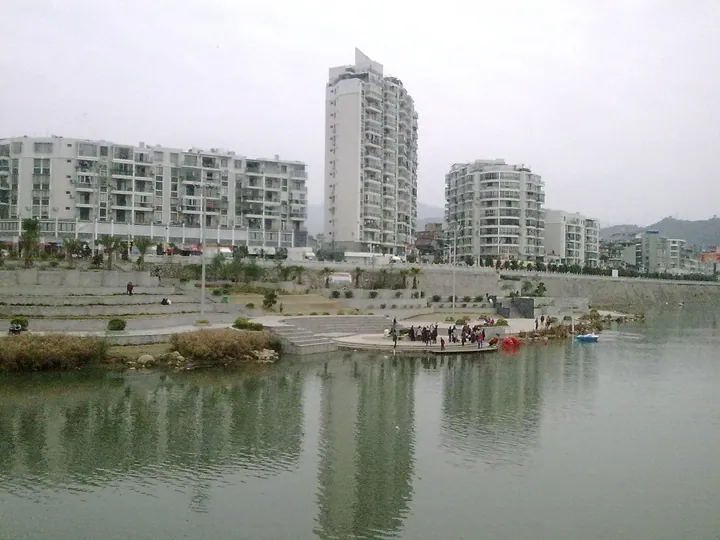 Apartment towers beside a lake with a lakeside plaza in Fu'an