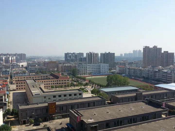 Elevated view of Yongxiu County's built-up area, including a school campus and high-rise apartments