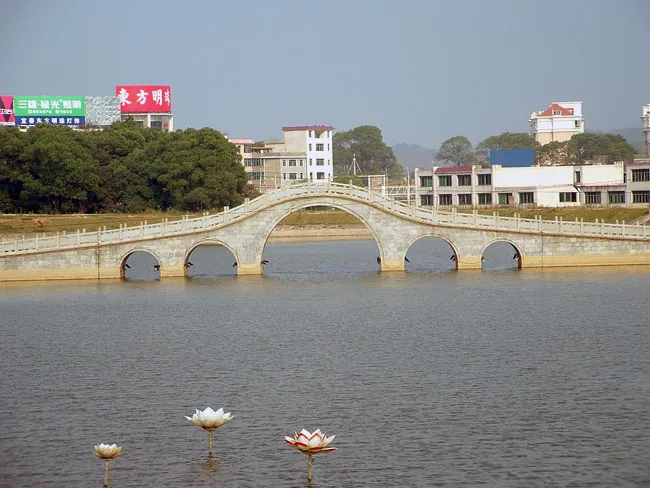 Stone arch bridge with lotus decorations over a lake, Yuanzhou District