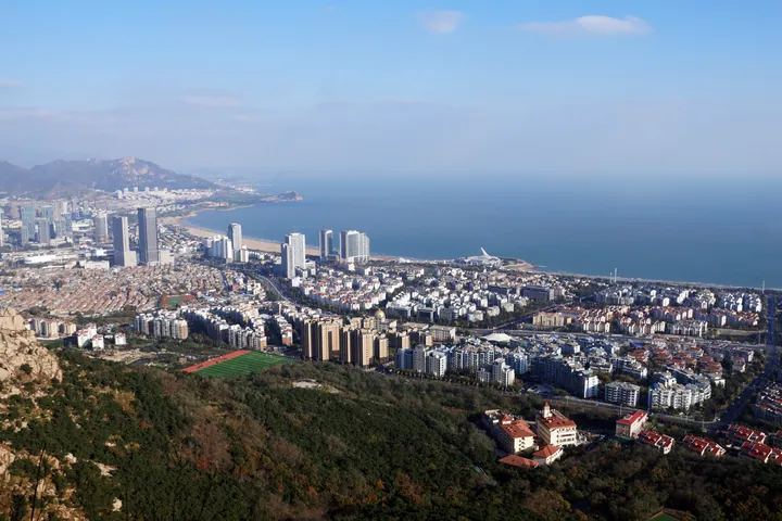 Aerial view of Qingdao's coast and high-rises from a hillside