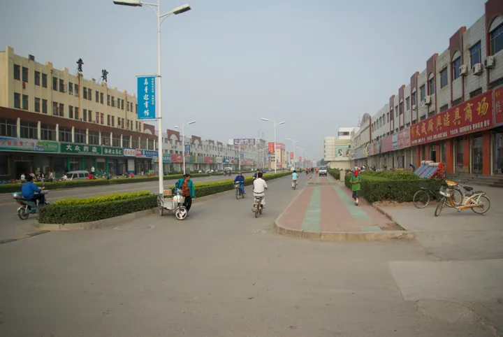 A street with shops, scooters and pedestrians in a county town