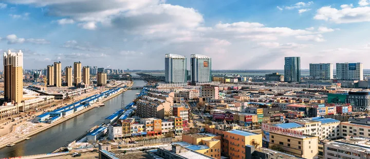 An aerial view of a river running through a city with high-rises