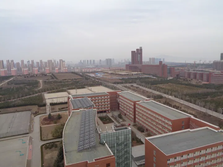 An aerial view of university buildings with the city skyline behind