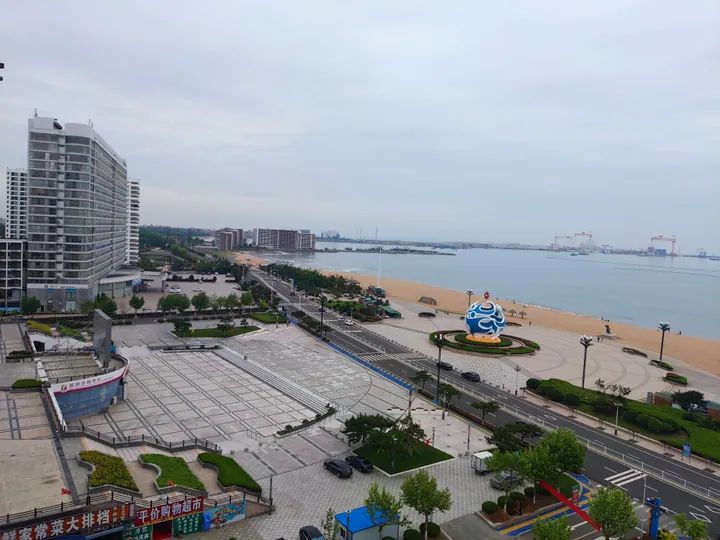 Beach and sand sculpture park with a large blue sculpture in Haiyang