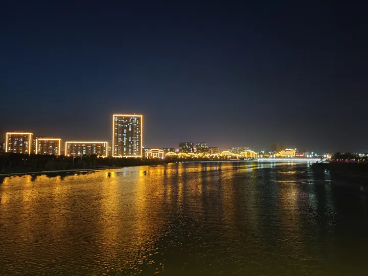 Illuminated riverside skyline of Linqu County at night