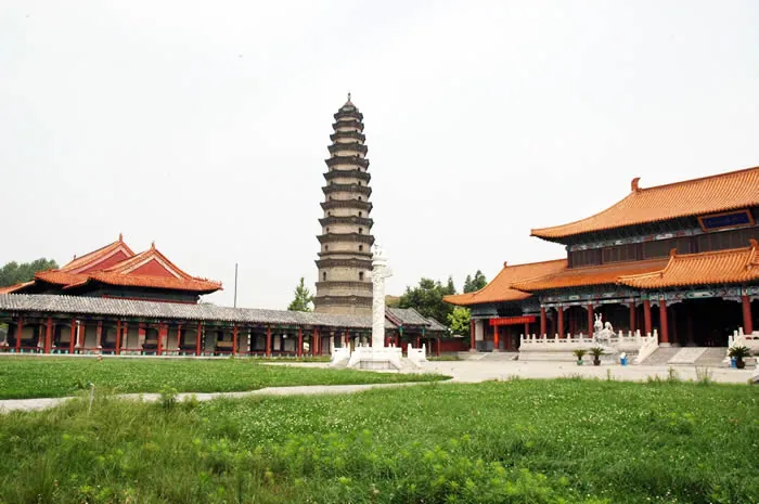 A tall brick pagoda flanked by red temple halls in Wenshang County, China