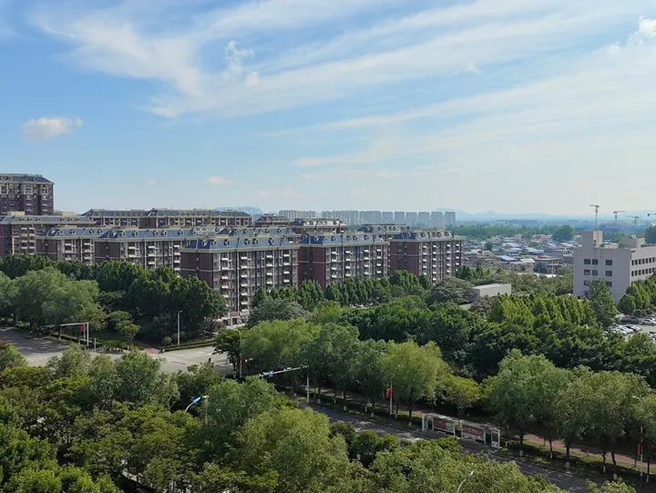Apartment towers with green space and hills in the background, Sishui County