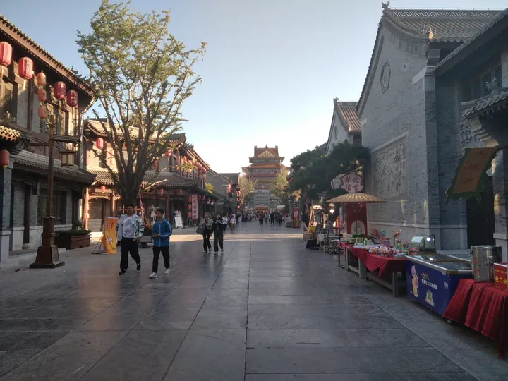 Pedestrian street lined with traditional buildings and lanterns in Ju Ancient City