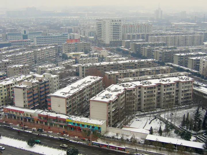 Aerial view of a snow-covered residential cityscape in Luoyang