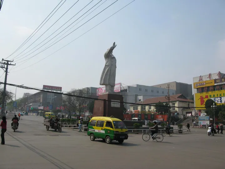 Statue of Mao Zedong in a busy street plaza