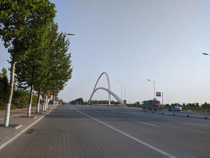 A modern double-arch bridge over a wide street, Puyang County