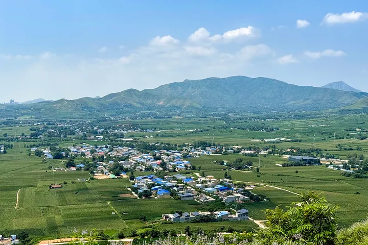 Mountain valley landscape with a village and farmland