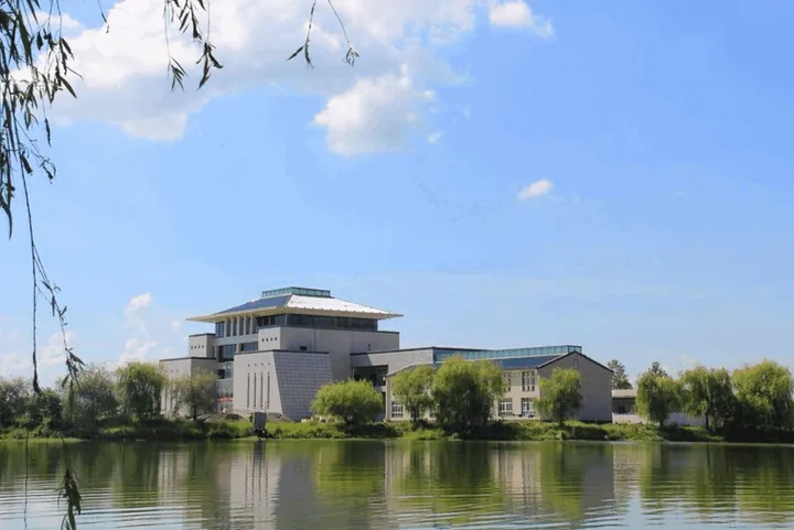 Modern museum building with lakeside reflection in Huaibin County