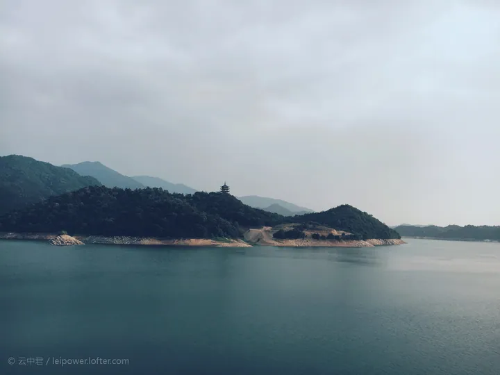 A wooded hillside with a pagoda overlooking Jiubujiang Reservoir in You County