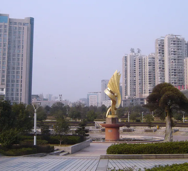 A golden bird sculpture in a plaza surrounded by high-rise buildings in Yuetang District, Xiangtan
