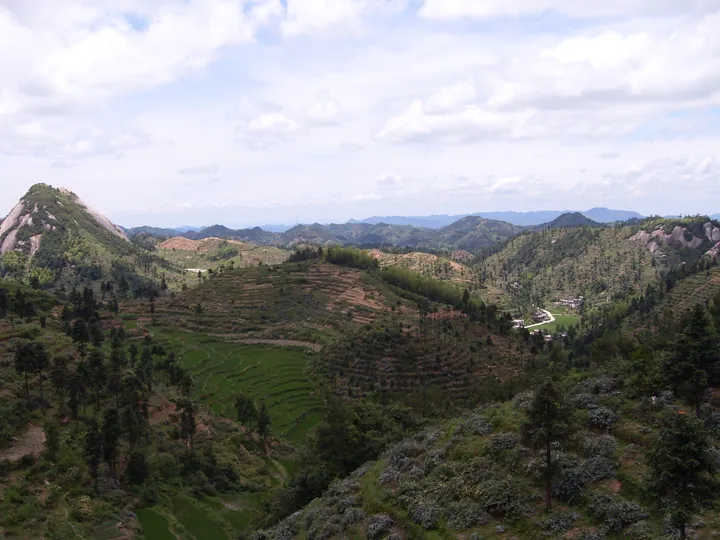 Terraced fields and a village nestled among green hills in Longhui County