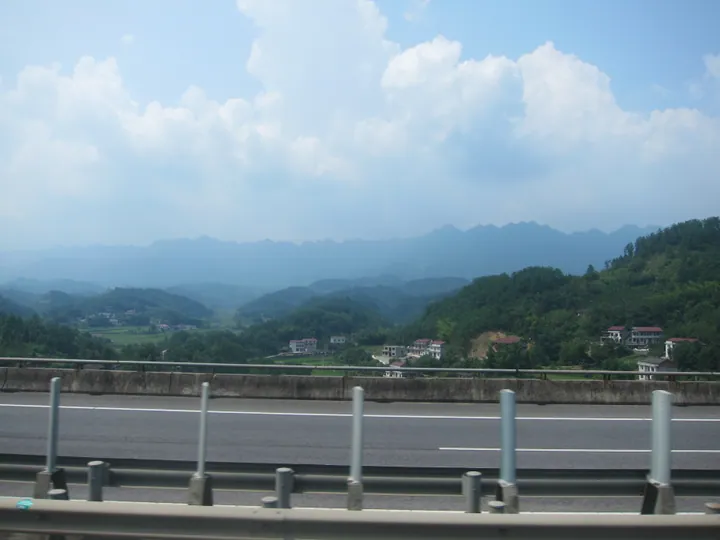 Green mountain valley with scattered houses in Cili County