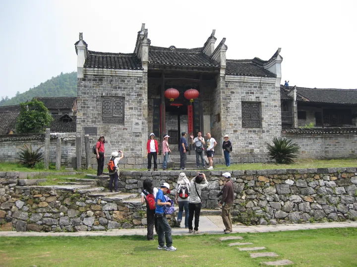 Historic grey-stone building with tourists gathered in front