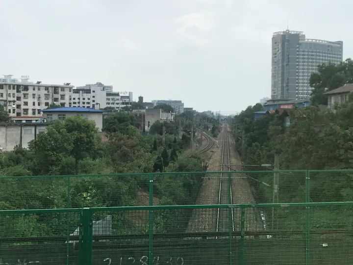 Railway tracks converging toward city buildings in Hecheng District