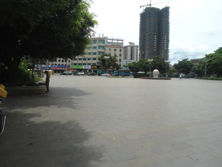 Open public square with palm trees and buildings in Xuwen town